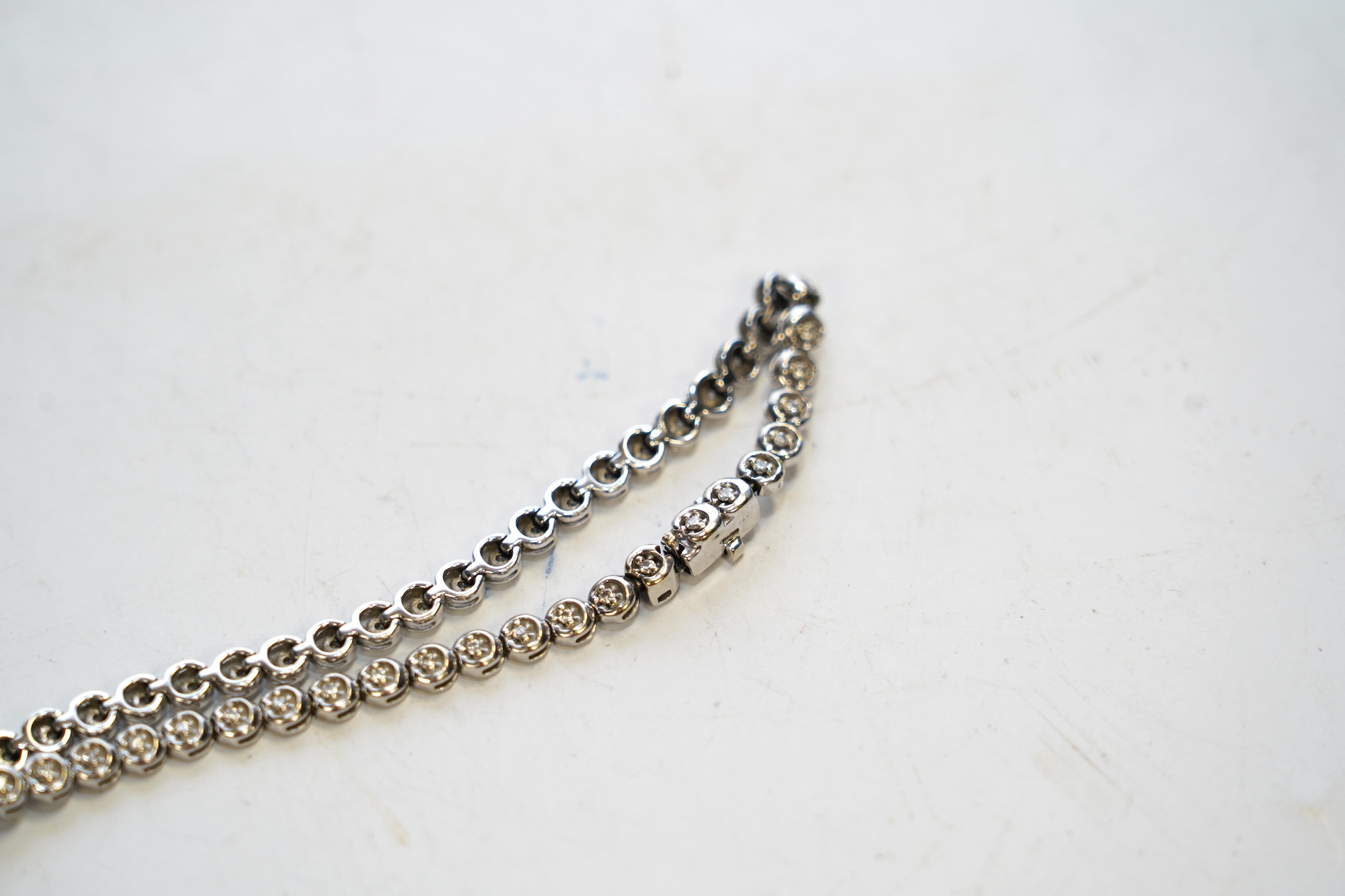 A modern 9ct white gold and diamond chip set line bracelet, 19.5cm, gross weight 8.9 grams. Condition - fair